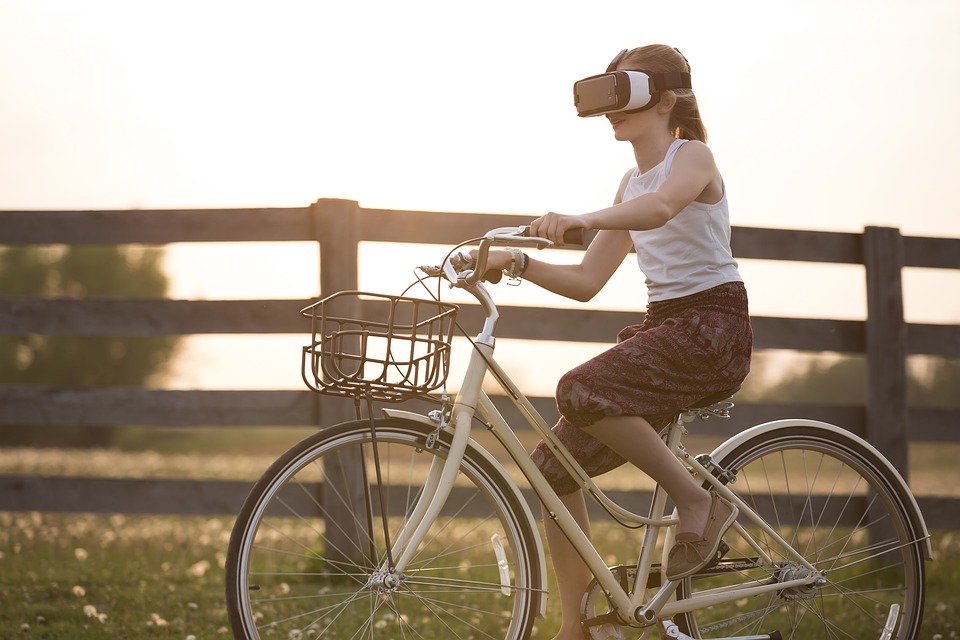 ragazza corre in bicicletta con l'aiuto della realtà virtuale