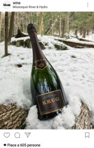 Bottiglia di champagne poggiata sulla neve. Foto usata in un profilo instagram come content marketing
