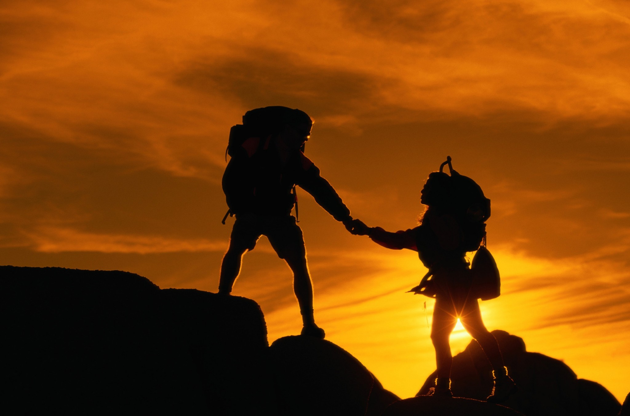 Economia della fiducia nello sport. Due alpinisti si aiutano nella salita su una montagna