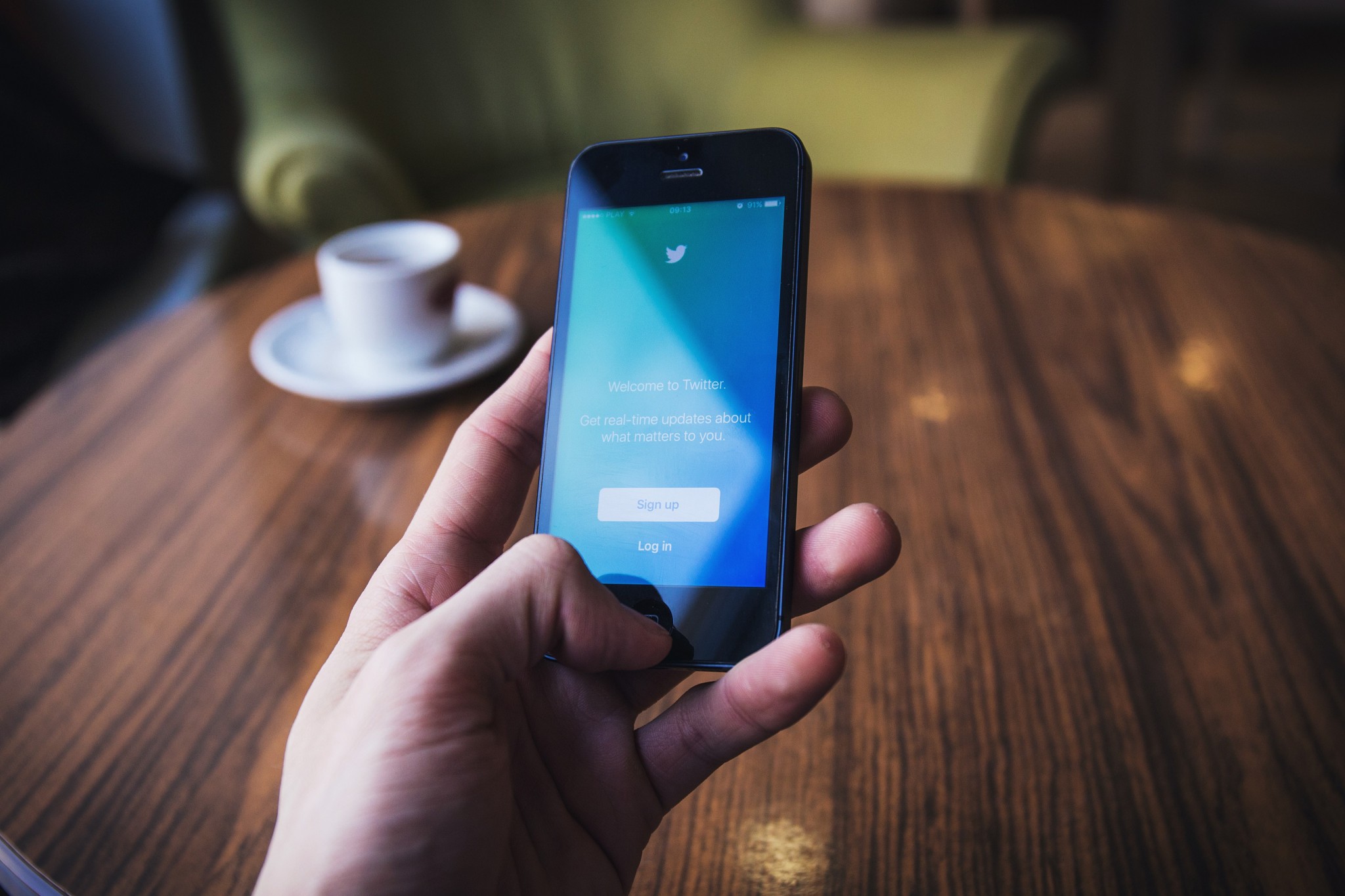 Una mano tiene un cellulare con l'app di twitter durante un live tweeting
